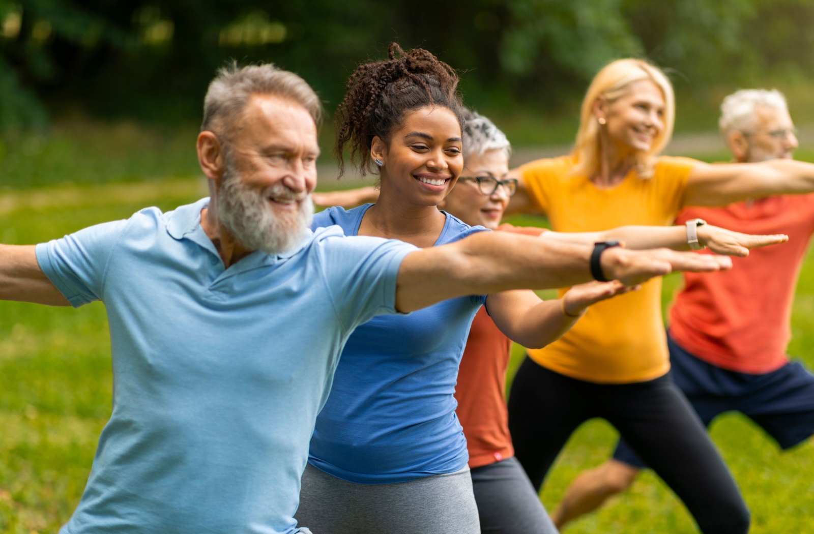 A group of seniors are doing a group yoga class to help with arthritis pain management.