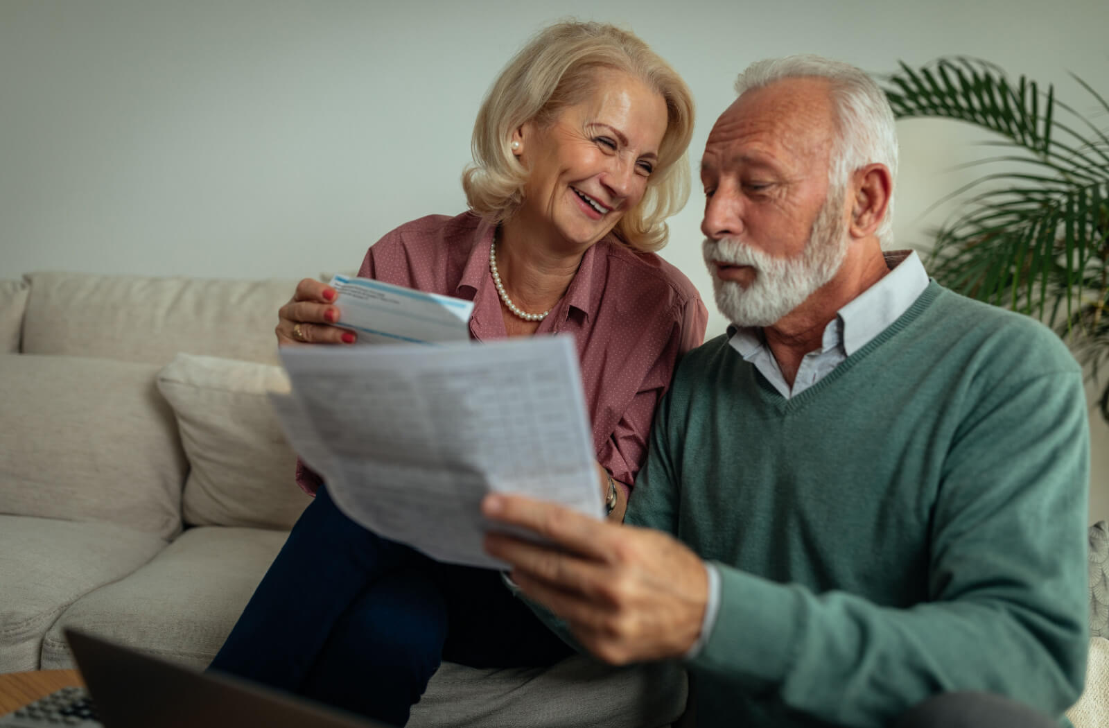 A married older couple working from their couch to research potential senior living communities.