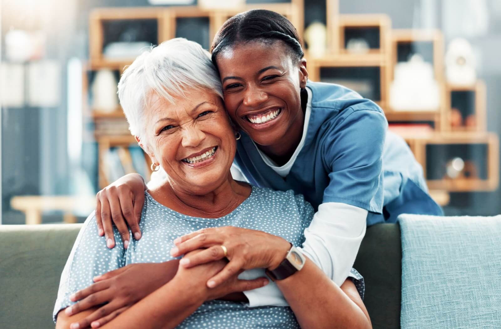 A staff member in an assisted living community hugs a resident, demonstrating close bonds within the community